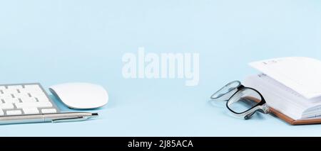 Pc keyboard, mouse and pen on blue background with copy space Stock Photo