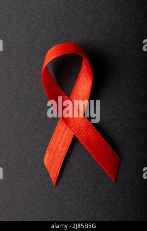 Overhead close-up of red aids awareness ribbon isolated against black background, copy space Stock Photo