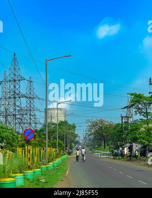 Portrait View of City Traffic overlooking Factory Cooling Tower. Selective Focus is used. Stock Photo