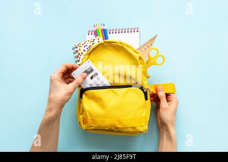 Yellow school backpack with colorful school stationery Stock Photo
