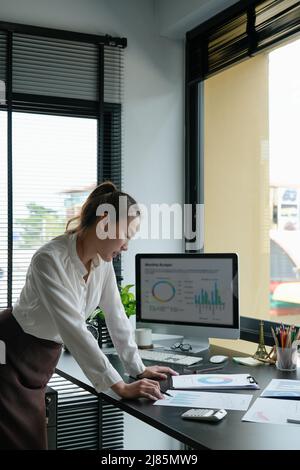 Business woman using calculator for do math finance on wooden desk in office and business working background, tax, accounting, statistics and analytic Stock Photo