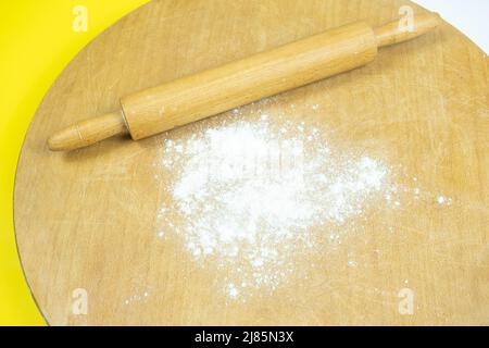 Rolling pin on traditional circle wooden board, top view of roller and some flour, cooking concept, making homemade bread Stock Photo