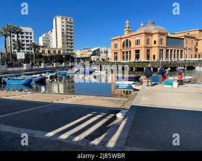 Bari, Italy. Fishing boats docked in the Porto Bari marina, with Museo Teatro Margherita building in the back. Stock Photo