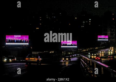 Beirut, Lebanon. 12th May, 2022. Campaign posters for the parliamentary elections light up a street amid a blackout in the city, ahead of the May 15 parliamentary elections. (to dpa 'Women against the 'government mafia' - Lebanon votes in crisis Parliament') Credit: Marwan Naamani/dpa/Alamy Live News Stock Photo