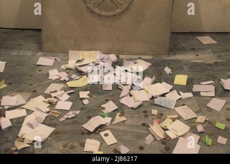 Bari, Italy. The crypt of the St. Nicholas Church (Basilica San Nicola, b. 11th century). Money and prayers in front of a Byzantine icon of the saint. Stock Photo