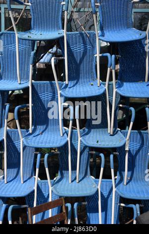 Display of Stacked Vintage or Antique Blue Plastic Bistro Chairs in Antique Shop L'Isle-sur-la-Sorgue Vaucluse Provence France Stock Photo