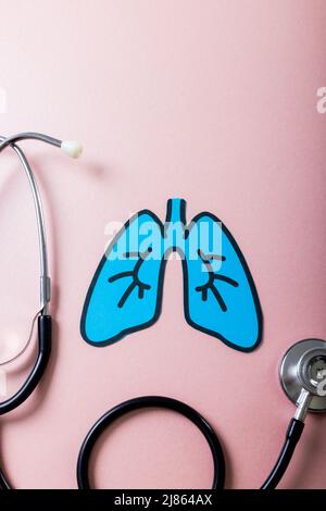 Overhead view of blue paper lungs with stethoscope against pink background, copy space Stock Photo