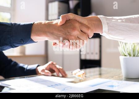 Financial Graph And Diagram. Analyst Shake Hands In Meeting Stock Photo