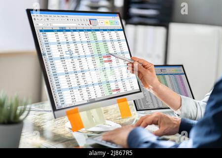 Analyst Employee Working On Spreadsheet Using Desktop Computer Stock Photo