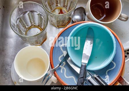 Dirty dishes, glasses, cutlery in kitchen sink Stock Photo