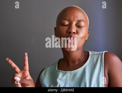 A young Black model poses with peace sign and kisses Stock Photo