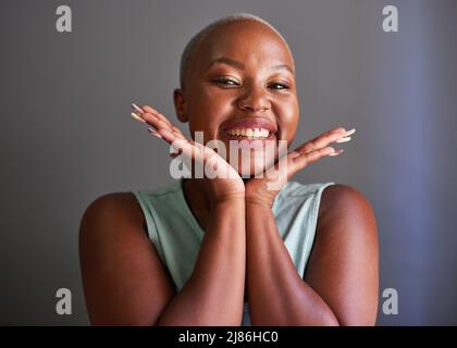 A young Black model holds hands under her face posing Stock Photo