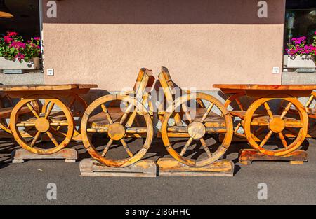 Biel, Switzerland - Mai 11, 2022: Wooden outdoor inn benches in the shape of a peasant wagon Stock Photo