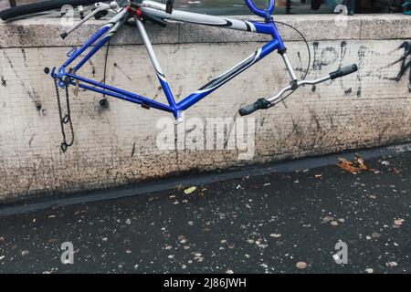 Abandoned vandalized bicycle missing wheels and saddle left on the city street Stock Photo