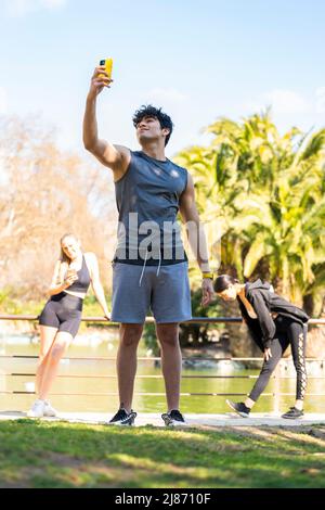 Young sportsman makes a break to take a selfie in the park Stock Photo