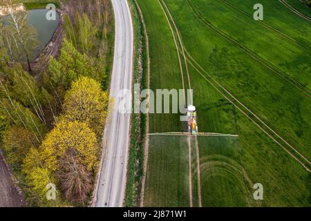 top down view of the tractor spraying the chemicals on the large green field, agriculture concept Stock Photo