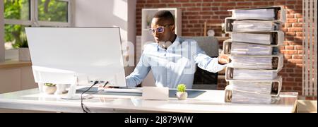 Businessperson Pushing Paper Documents Away And Working With Digital Documents On Computer Instead Stock Photo