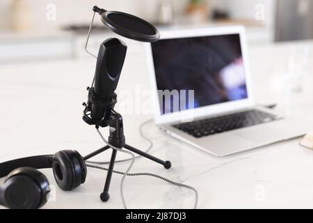 Close-up of microphone with headphones and laptop on white table at home, copy space Stock Photo