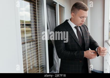 Businessman adjusting jacket on balcony. High quality photo Stock Photo