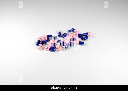 Amoxicillin capsules on a white background; antibiotic used to treat bacterial infections; doctor prescribed medication for infection treatment. Stock Photo
