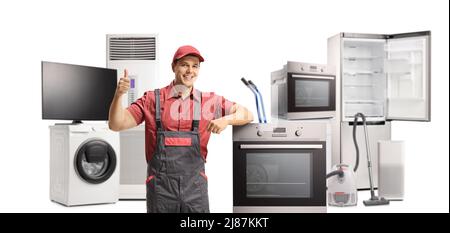 Handyman in a uniform standing next to electric appliances and giving thumbs up isolated on white background Stock Photo