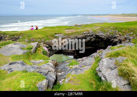 Fairy bridges, impressive stone arches near Tullan Strand, one of Donegals surf beaches, framed by a scenic back drop provided by the Sligo-Leitrim Mo Stock Photo