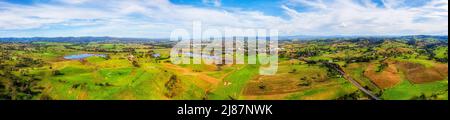 Wide aerial panorama of green lush cultivated pastures in dairy farms of Bega valley in Australia. Stock Photo