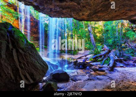 Behind Oakland waterfall in Hazelbrook creek of the Blue Mountains, Australia - behind the falling water stream. Stock Photo
