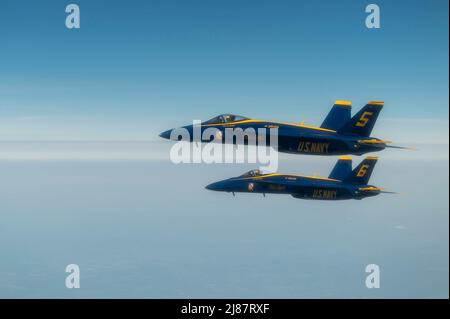 Two U.S. Navy Blue Angels fly alongside a KC-46A Pegasus assigned to the 916th Air Refueling Wing during an in-air refueling operation over Arkansas, May 11, 2022. The Blue Angels originally flew the F6F Hellcat, but throughout the decades they have flown several different aircraft as aviation technology has improved. (U.S. Air Force photo by Senior Airman Kevin Holloway) Stock Photo