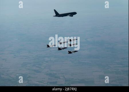 A KC-46A Pegasus assigned to the 916th Air Refueling Wing at Seymour Johnson Air Force Base, North Carolina, flies alongside the U.S. Navy Blue Angels after in-air refueling over Nebraska, May 11, 2022. The Blue Angels were traveling from Florida to Ellsworth Air Force Base, South Dakota, for an airshow the following weekend. (U.S. Air Force photo by Senior Airman Kevin Holloway) Stock Photo