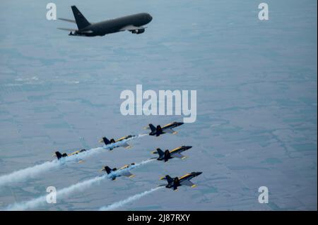 The U.S. Navy Blue Angels fly in formation alongside a KC-46A Pegasus assigned to 916th Air Refueling Wing, after being aerial refueled in the skies over Nebraska, May 11, 2022. The KC-46A helped sustain the Blue Angels by refueling during their flight from Florida to Ellsworth Air Force Base, South Dakota. (U.S. Air Force photo by Senior Airman Kevin Holloway) Stock Photo