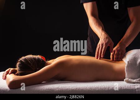 A man is a chiropractor doing a massage to a woman in the neck and trapezius  muscles in his office Stock Photo - Alamy