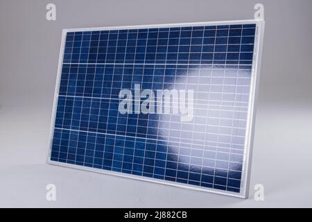 Sunlight reflecting on blue solar panel isolated against white background, copy space Stock Photo