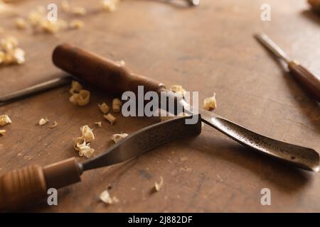 Close-up of various hand tools with wood shavings on workbench in workshop Stock Photo