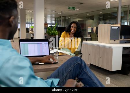 Happy biracial young businesswoman with hands clasped in meeting with african american businessman Stock Photo