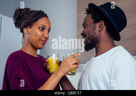 cropped shot of dark skinned couple making smoothies, pouring juice Stock Photo