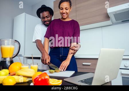 cropped shot of dark skinned couple making smoothies, pouring juice Stock Photo