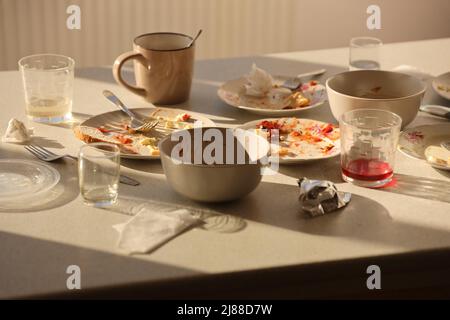Empty dirty plates with spoons and forks on the table after meal. Banquet ending concept. Unwashed dishes ready to cleaning Stock Photo