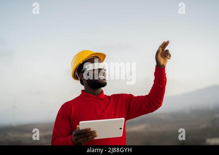 African engineer working with futuristic glasses on construction site - Technology and future industry concept Stock Photo