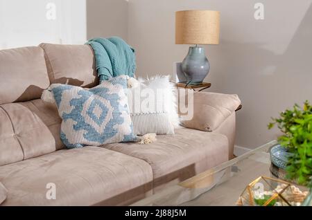 Close up of a sofa with styled cushions and throw.  Home decoration. Stock Photo