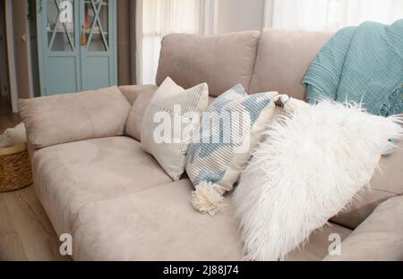 Close up of a sofa with styled cushions and throw.  Home decoration. Stock Photo