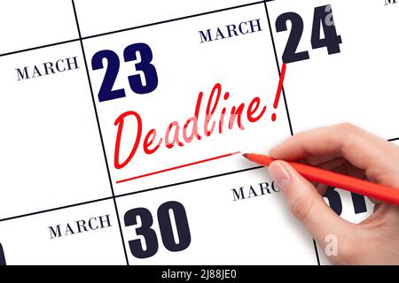 23rd day of March. Hand drawing red line and writing the text Deadline on calendar date March 23. Deadline word written on calendar Spring month, day Stock Photo