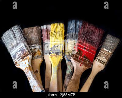 Bunch of used and dried paint brushes shot on black background Stock Photo