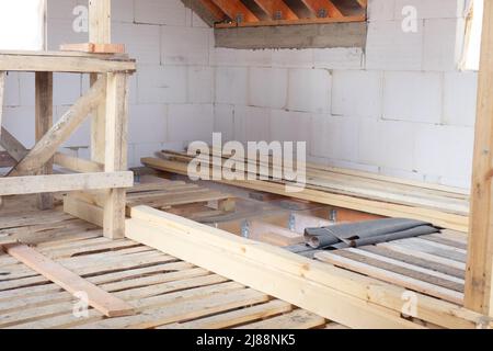 Construction of the floor on the second floor of the garage from wooden boards. White foam concrete walls Stock Photo