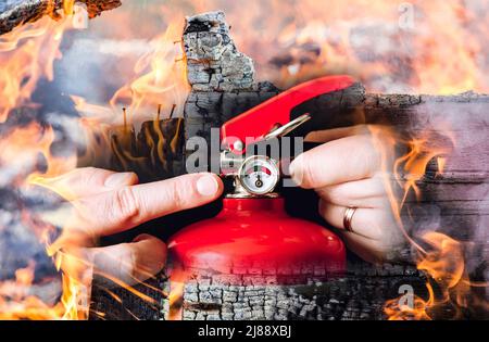 Close up view of man worker showing red fire extinguisher and controlling it. Maintenance service concept. Photo composite. Stock Photo