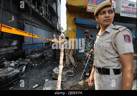New Delhi, India. 14th May, 2022. A Delhi Policewoman cop seen at the site of a fire in a commercial building a day after the fire broke out in a three-story commercial building near Mundka Metro Station on Friday late night. A massive fire broke out at a building near west Delhiís Mundka Metro Station on Friday evening, leaving 27 people dead and 12 injured, the police said. Credit: SOPA Images Limited/Alamy Live News Stock Photo