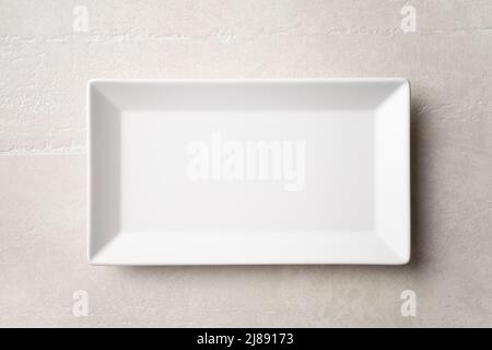 Rectangular white plate on a light stone background, the concept of food, restaurant Stock Photo