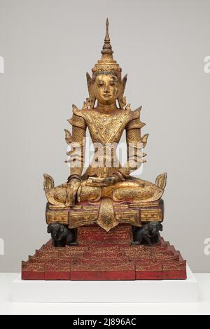 Crowned and Bejewelled Buddha Seated on an Elephant Throne, Late 19th century. Stock Photo