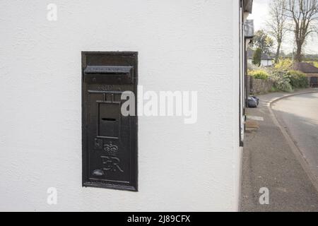 Royal Mail postbox set into wall of private house, painted black and blocked up to prevent use, Govilon, Wales, UK Stock Photo