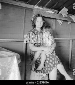 Tulare County, California. In Farm Security Administration (FSA) camp for migratory agricultural workers. Mother with sick baby awaits arrival of FSA camp resident nurse. Stock Photo